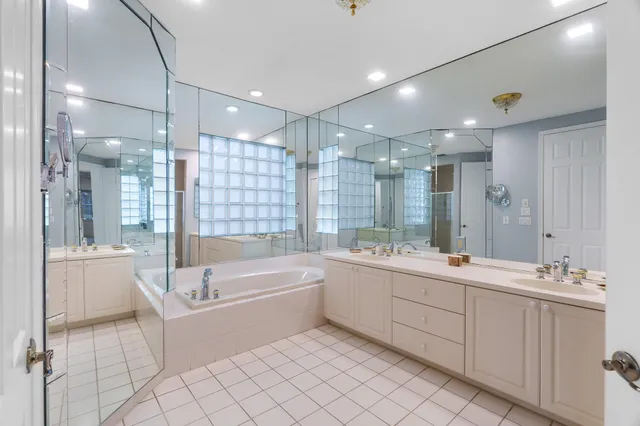 a bathroom with a large tub sink shower and mirror