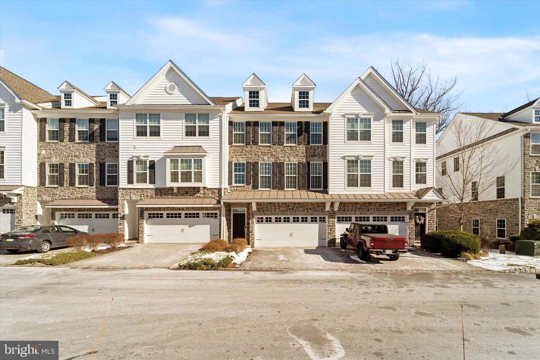 a front view of a building with lot of cars and trees