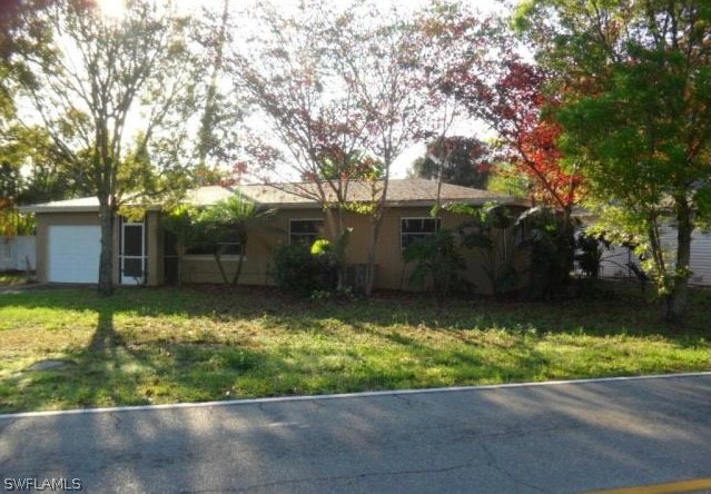 5403 Winkler Road Fort Myers, FL 33919 - Photo 1 of 1 a front view of a house with a yard and a large tree