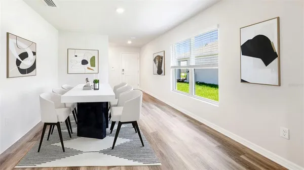 a dining room with wooden floor and a table