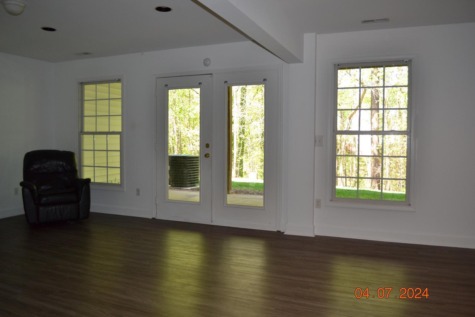 4506 Mistiflower Drive Raleigh, NC 27606 - Photo 15 of 27 a view of an empty room with wooden floor and a window