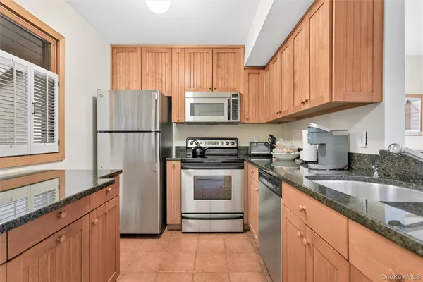 a kitchen with granite countertop a refrigerator stove and microwave