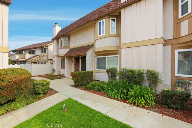 a view of a white house next to a yard