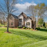 a front view of a house with a yard and trees