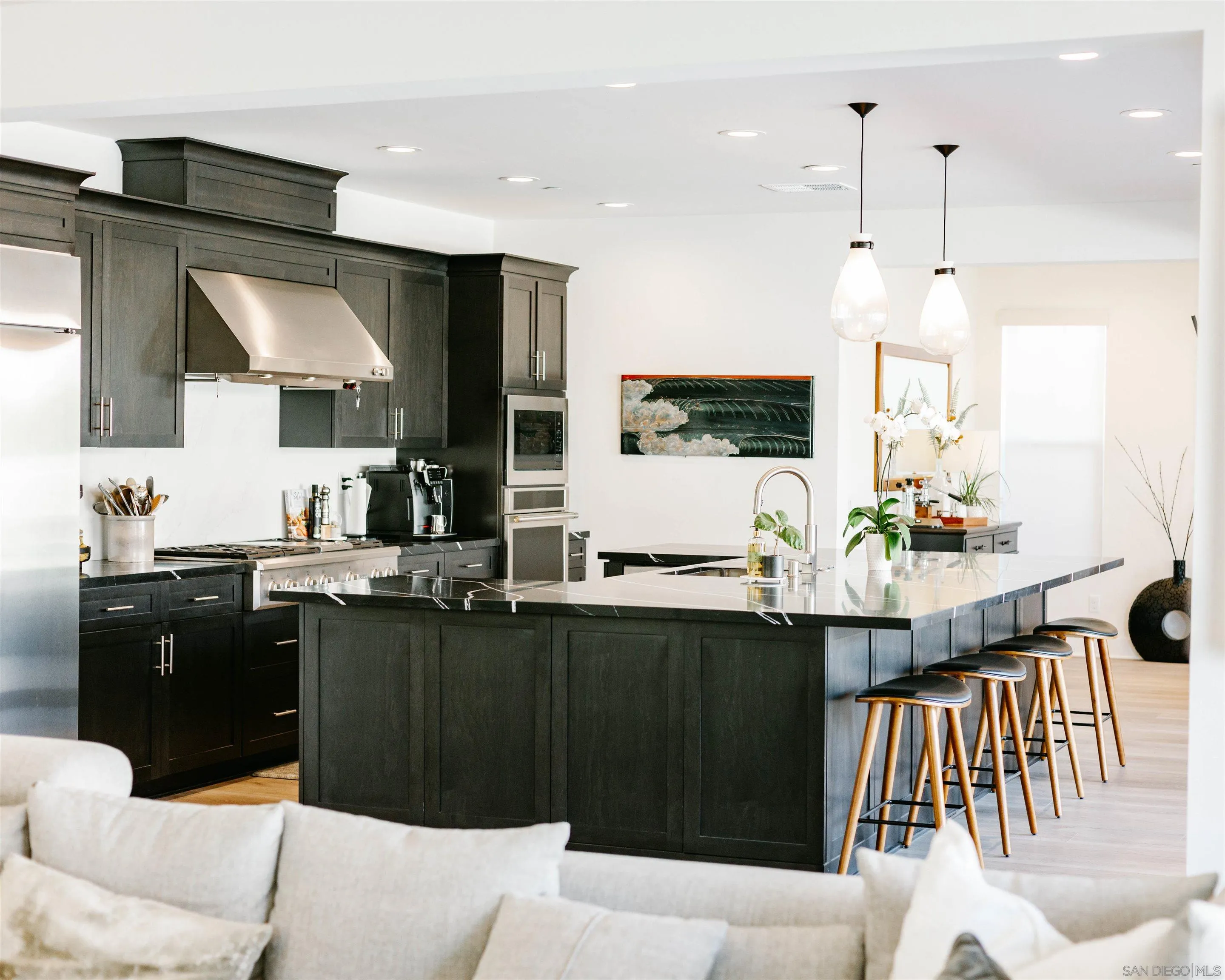 927 Moonstone Court Encinitas, CA 92024 - Photo 12 of 31 a kitchen with stainless steel appliances kitchen island granite countertop a sink a stove a dining table and chairs