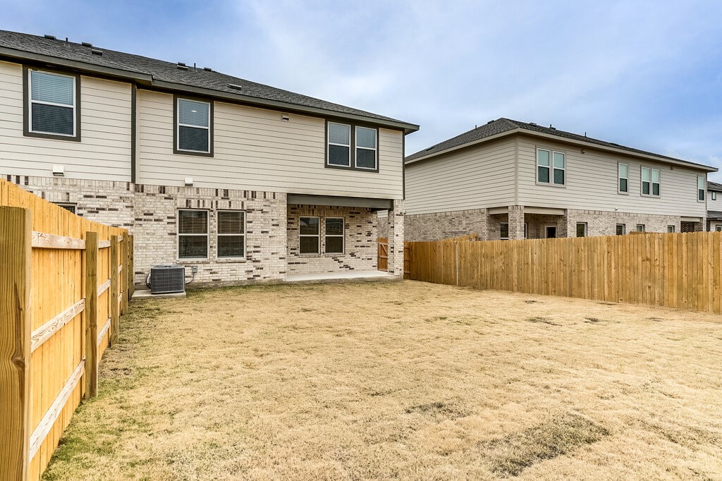 14824 Grey Ghost Way, Unit A Manor, TX 78653 - Photo 19 of 20 a view of a house with wooden fence