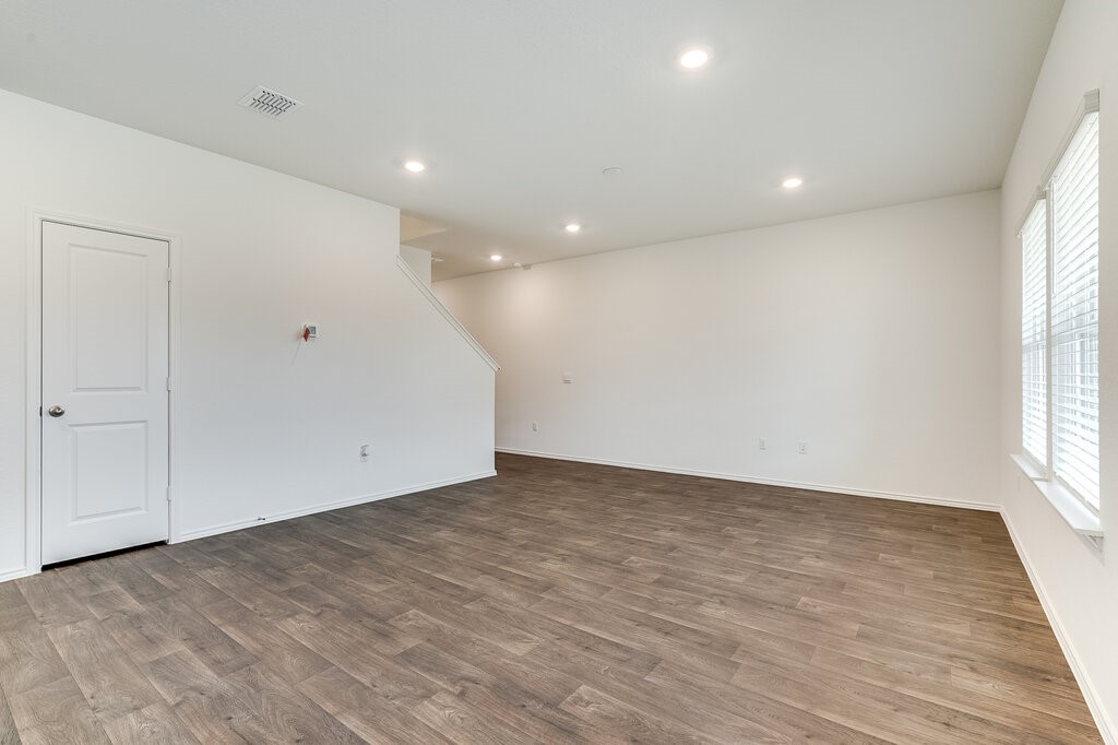 14824 Grey Ghost Way, Unit A Manor, TX 78653 - Photo 5 of 20 a view of an empty room with wooden floor and a window