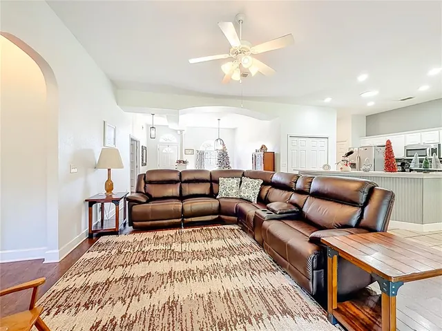 a living room with furniture a flat screen tv and a large window