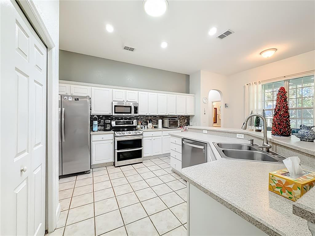 2301 Southeast 22nd Loop Ocala, FL 34471 - Photo 15 of 55 a kitchen with a sink a stove top oven and refrigerator