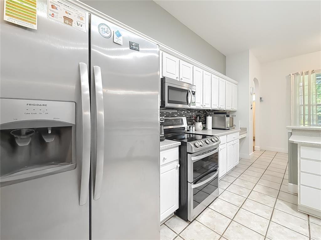 2301 Southeast 22nd Loop Ocala, FL 34471 - Photo 18 of 55 a kitchen with stainless steel appliances granite countertop a refrigerator a stove and a sink with cabinets