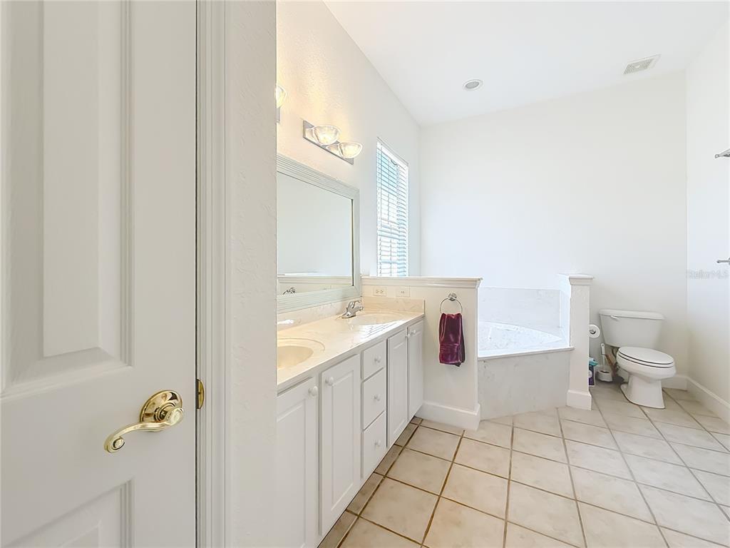 2301 Southeast 22nd Loop Ocala, FL 34471 - Photo 27 of 55 a bathroom with a granite countertop sink a toilet and a mirror