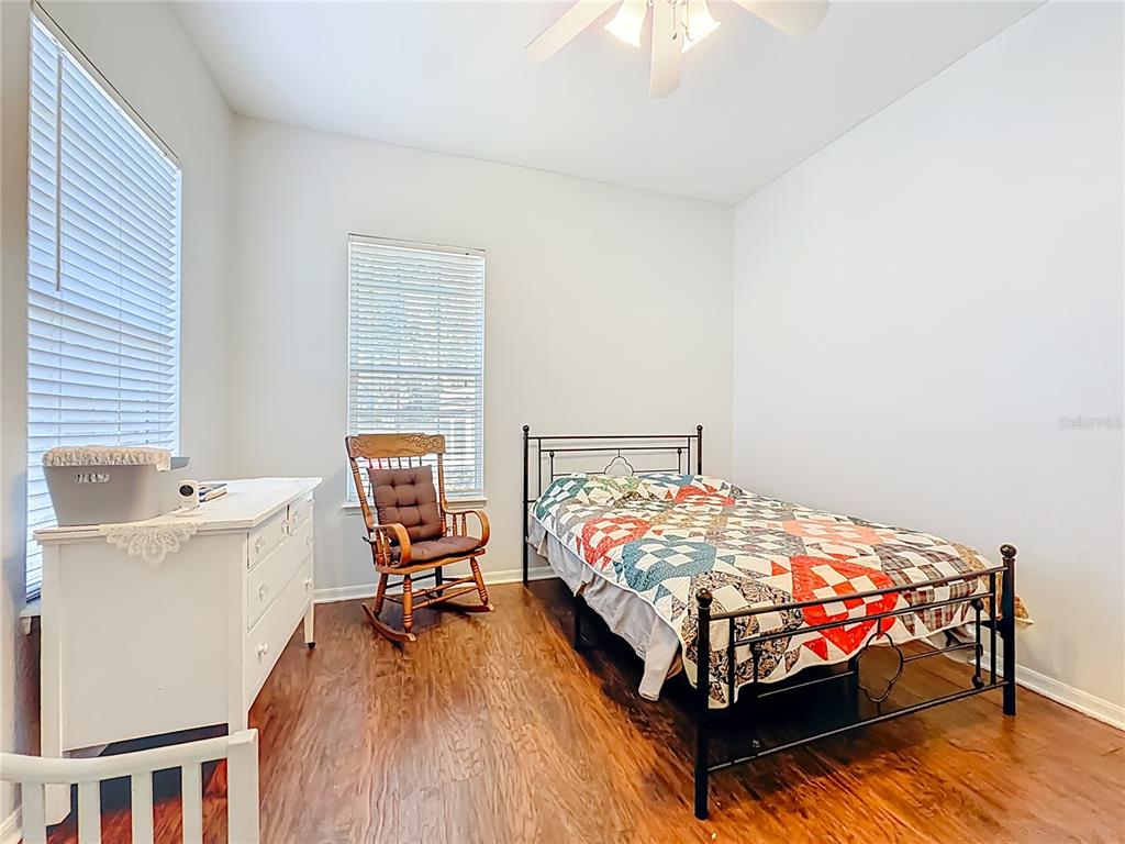 2301 Southeast 22nd Loop Ocala, FL 34471 - Photo 34 of 55 a bed sitting in a bedroom next to a window with chair