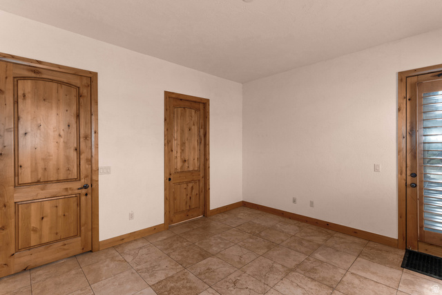 2464 East Granite Way St. George, UT 84790 - Photo 72 of 106 Empty bedroom with door on left leading to hallway/entrance of home, door in middle leading to bathroom, and door on right that leads to outside (west side of house)