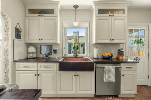 a kitchen with stainless steel appliances white cabinets and a window