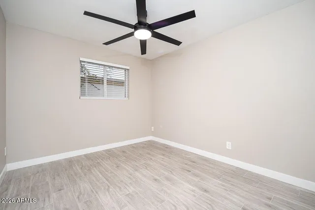 an empty room with a window and a fan