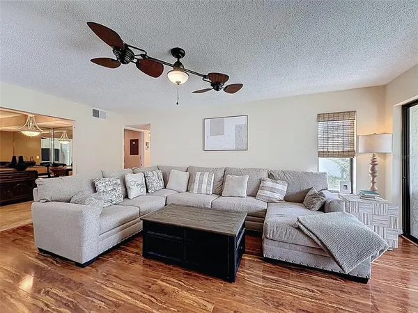 a view of a dining room with furniture a chandelier and wooden floor