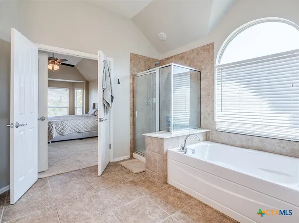 a spacious bathroom with a tub and a large window