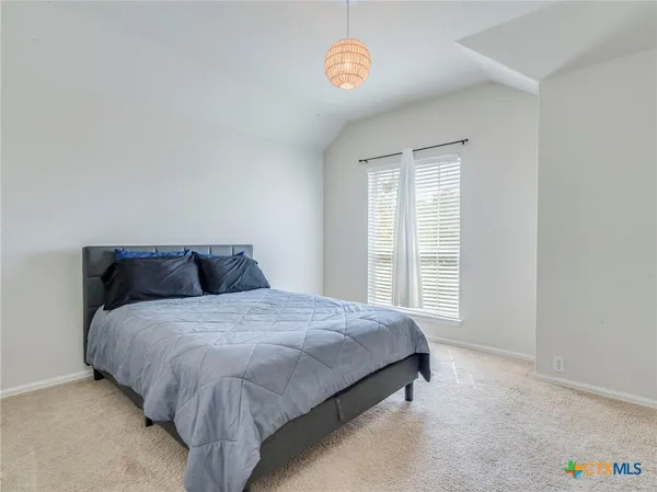 a spacious bedroom with a bed and a window