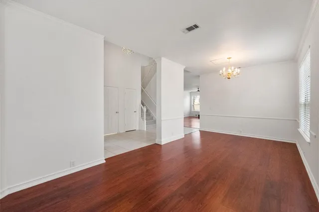an empty room with wooden floor a fireplace and windows