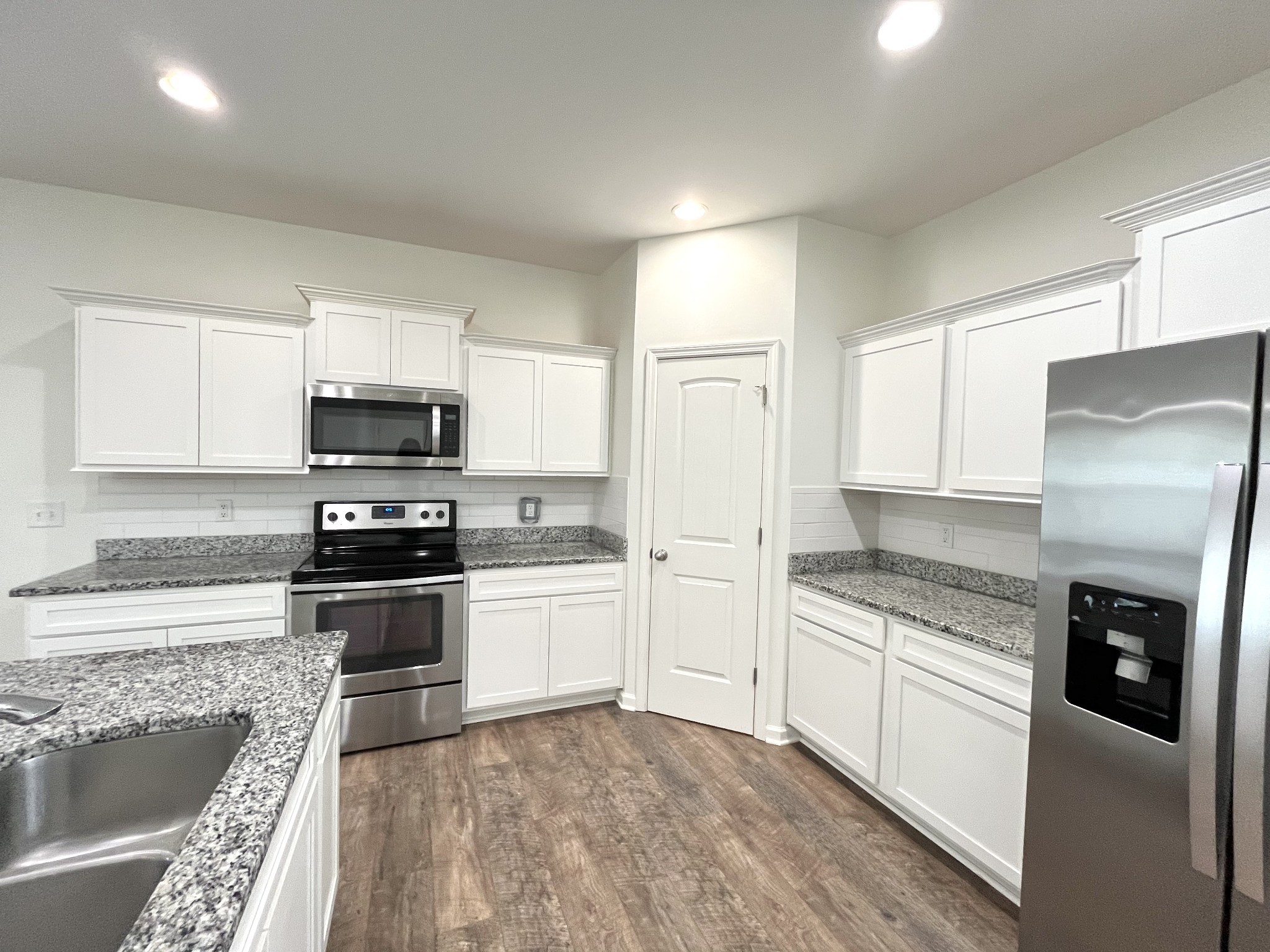 105 East Coker Way Spring Hill, TN 37174 - Photo 12 of 23 a kitchen with granite countertop a refrigerator stove and microwave