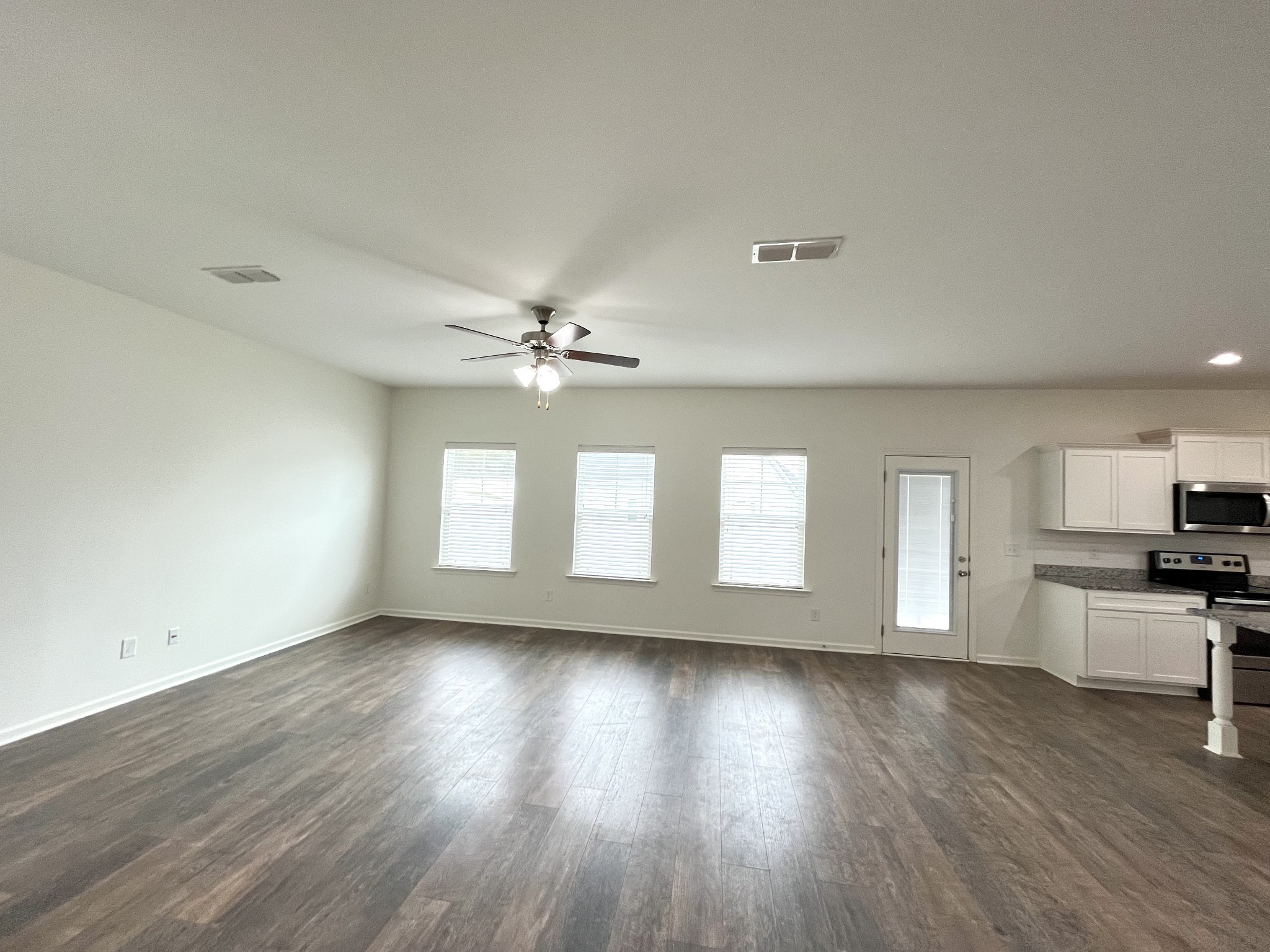 105 East Coker Way Spring Hill, TN 37174 - Photo 6 of 23 a view of a kitchen with a dishwasher a kitchen island hardwood floor and a window