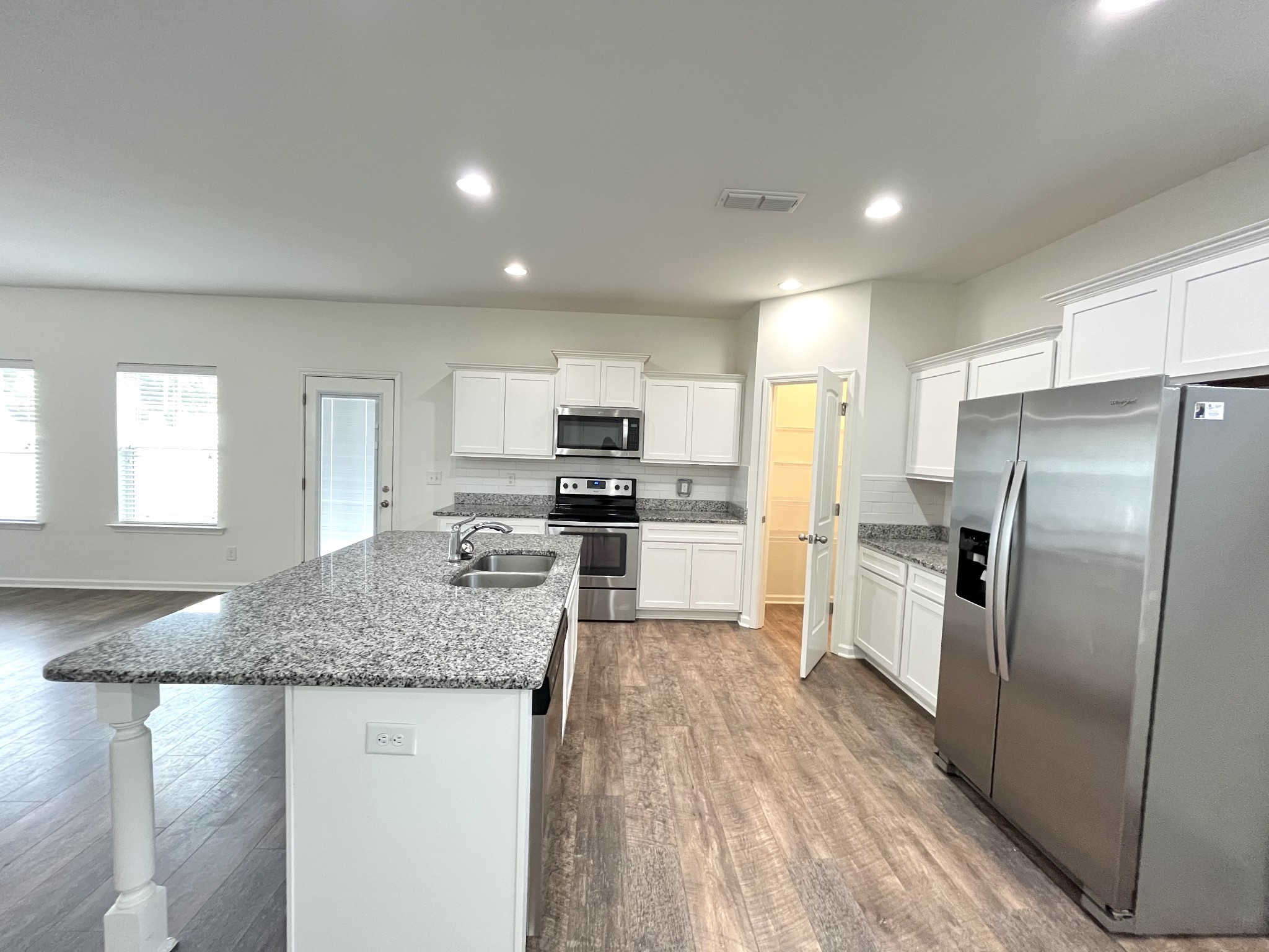 105 East Coker Way Spring Hill, TN 37174 - Photo 10 of 23 a kitchen with stainless steel appliances granite countertop a sink refrigerator and cabinets