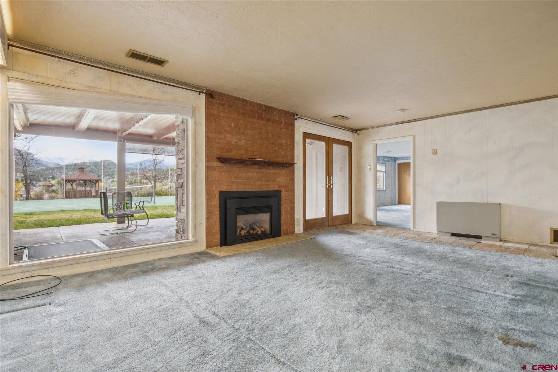 151 Riverview Drive Durango, CO 81301 - Photo 28 of 45 a view of an empty room with a fireplace and a window