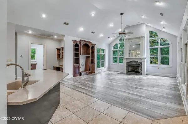 a kitchen with stainless steel appliances granite countertop a sink a stove and a wooden floors