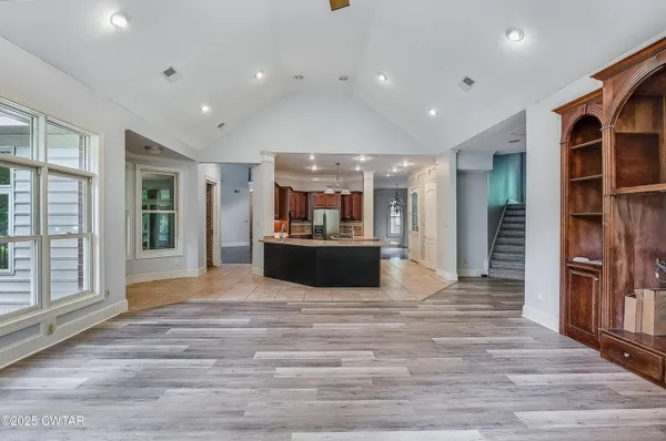 a view of large kitchen with a sink and refrigerator