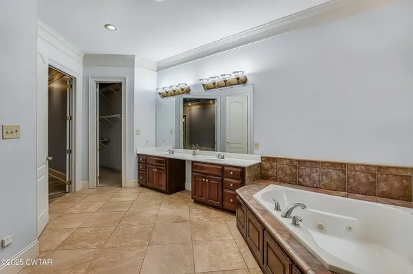 a spacious bathroom with a sink a large mirror and a bathtub