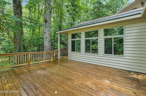 a view of a house with wooden deck and furniture