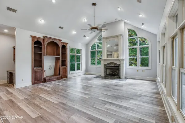 a view of a livingroom with a fireplace ceiling fan and window