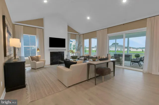 a living room with furniture a fireplace and a large window