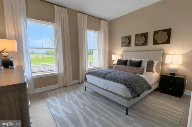 a bedroom with a bed a window and a flat screen television