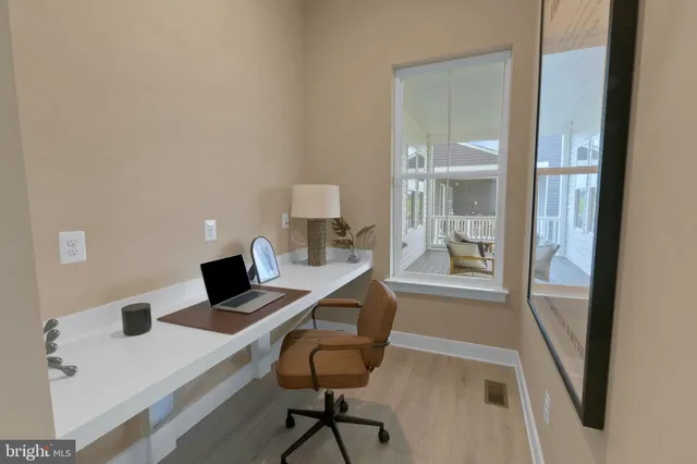 a view of a workspace with furniture and a window