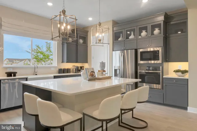 a kitchen with granite countertop a refrigerator a sink a stove a dining table and chairs