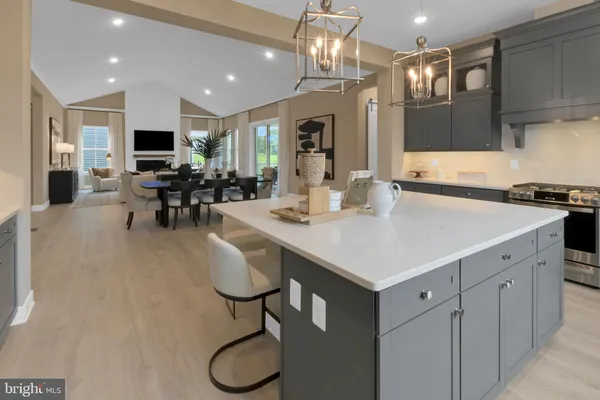 a kitchen with stainless steel appliances granite countertop a sink dishwasher a dining table and chairs with wooden floor