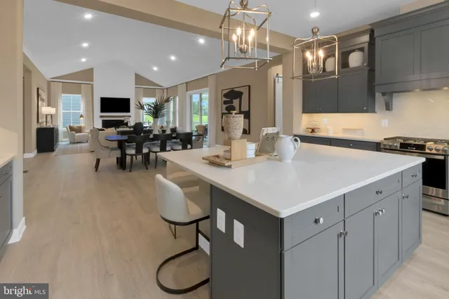 a kitchen with stainless steel appliances granite countertop a sink dishwasher a dining table and chairs with wooden floor