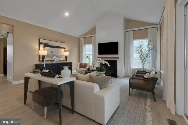 a living room with furniture a flat screen tv and a window