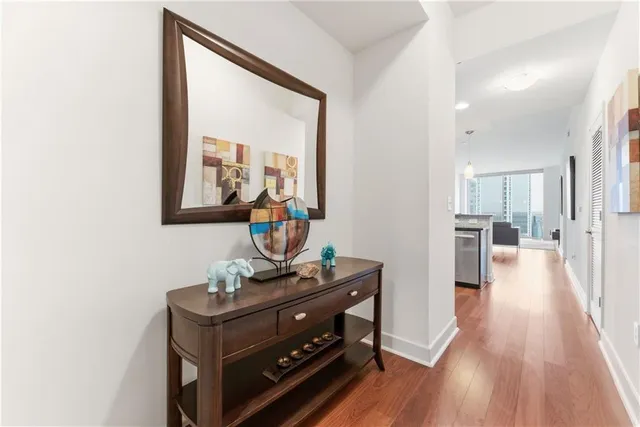 a view of a hallway with wooden floor and furniture