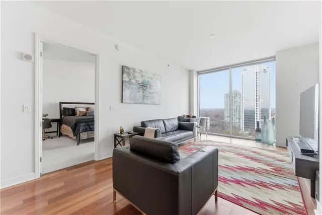 a living room with furniture and a floor to ceiling window