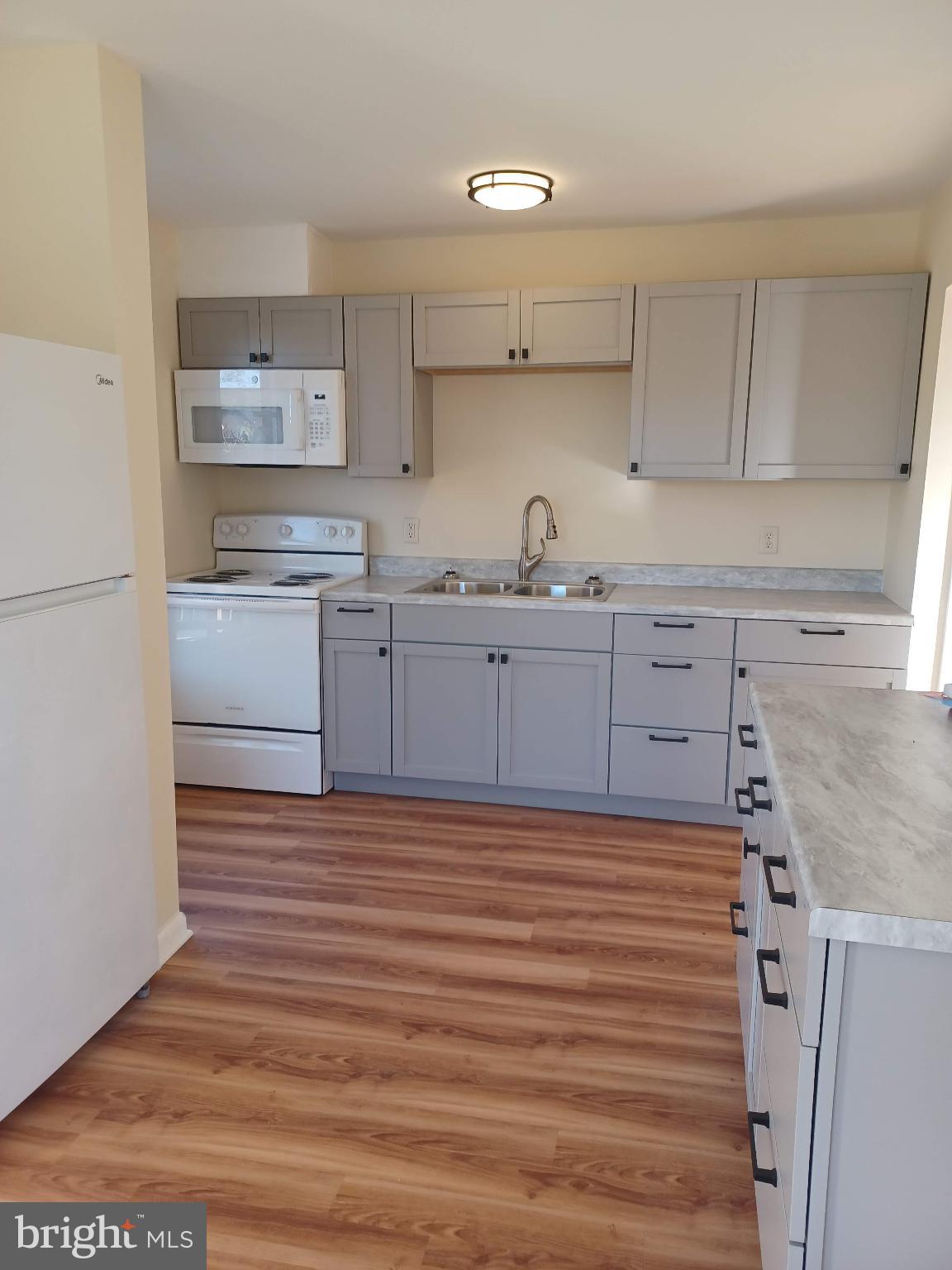 202 East Whitlock Avenue Winchester, VA 22601 - Photo 2 of 8 a kitchen with granite countertop white cabinets and white appliances