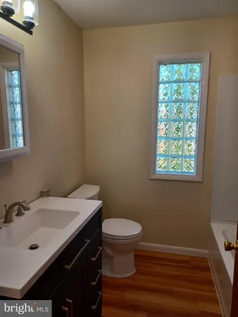 a bathroom with a sink a toilet and a window