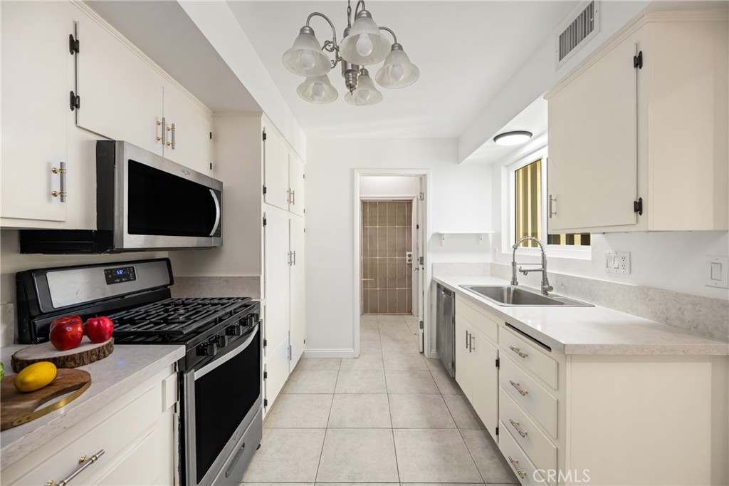 96 Seton Road Irvine, CA 92612 - Photo 22 of 51 a kitchen with stainless steel appliances a sink dishwasher stove and refrigerator with wooden cabinets