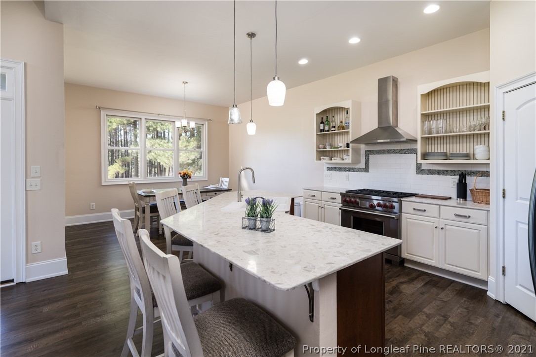 Undisclosed Address Aberdeen, NC 28315 - Photo 11 of 33 a kitchen with granite countertop a table chairs stainless steel appliances and wooden floor