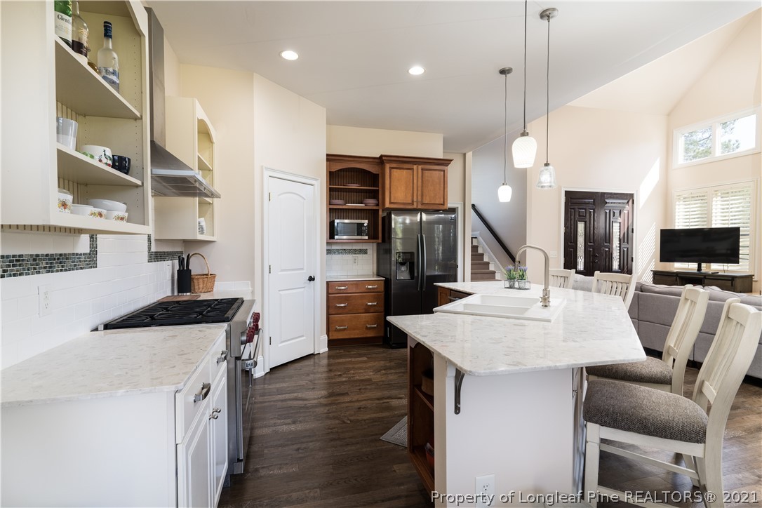 Undisclosed Address Aberdeen, NC 28315 - Photo 12 of 33 a kitchen with stainless steel appliances kitchen island granite countertop a table chairs and a refrigerator