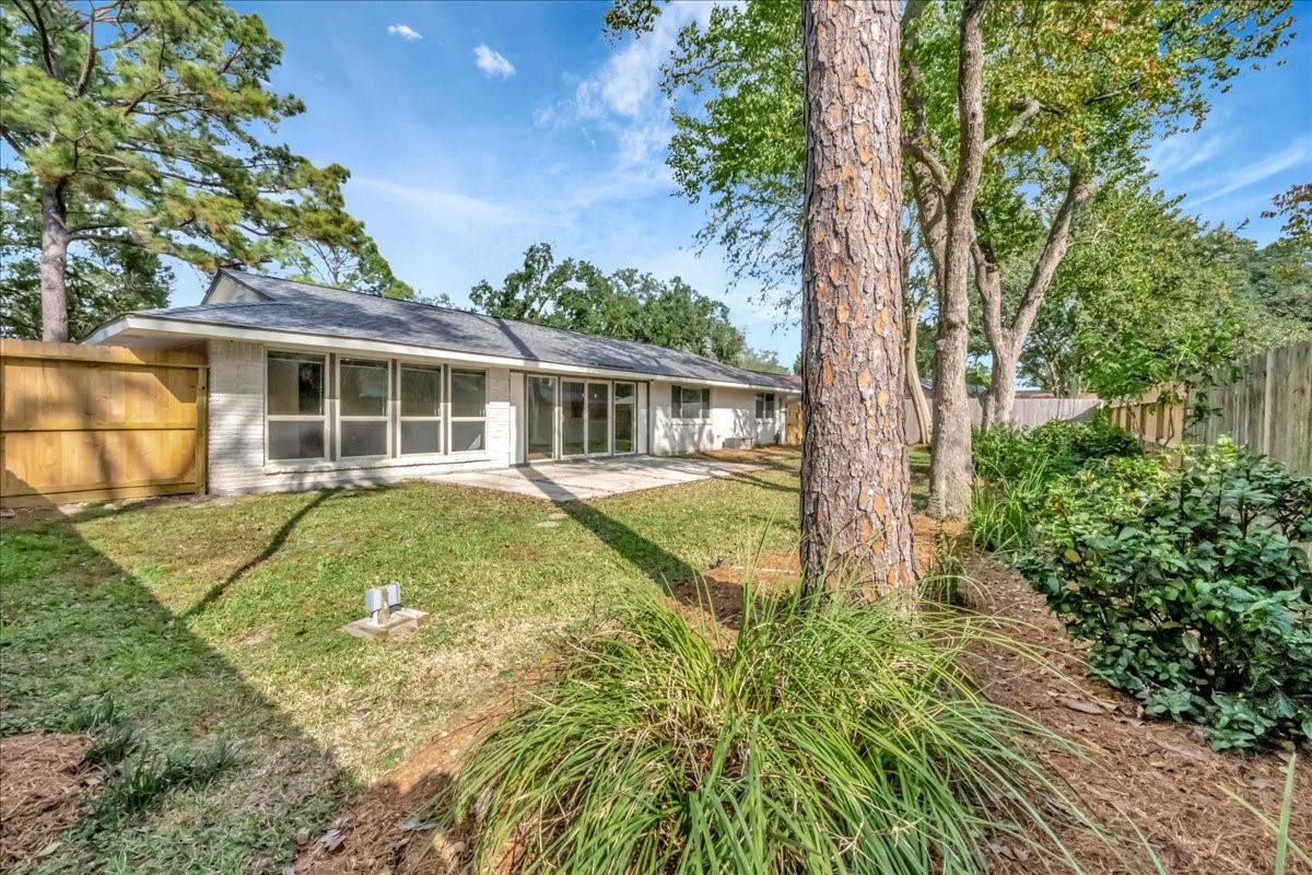1614 Wavecrest Lane Houston, TX 77062 - Photo 3 of 42 Backyard view toward the house, note all the replaced / updated windows throughout the entire house.