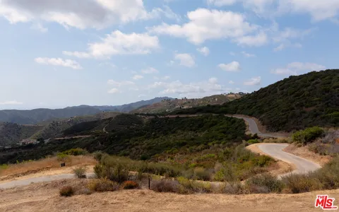 a view of a dry yard with mountains in the background