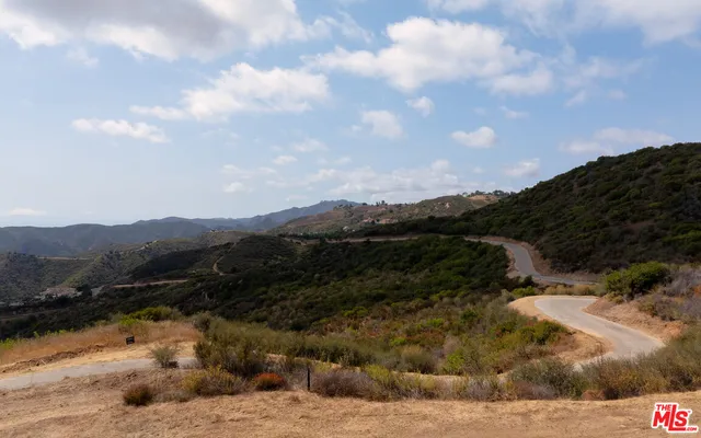 a view of a dry yard with mountains in the background