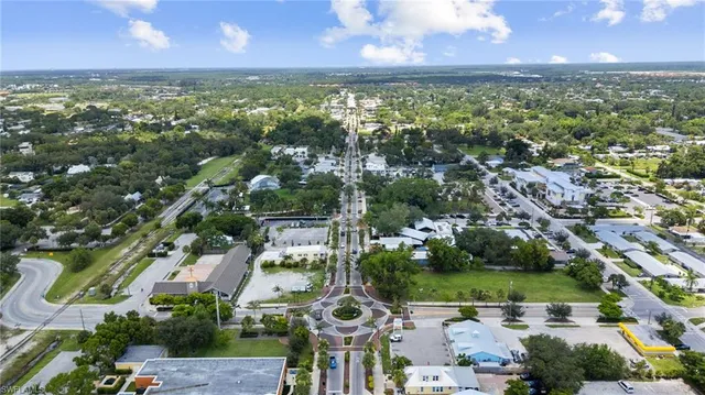 an aerial view of residential houses with outdoor space and trees